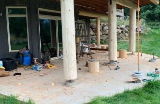 Replacing with an exterior glu lam beam. and we added another one to the prow of the deck to support the overhang. We also added the concrete footings and brackets to keep the logs off the ground.